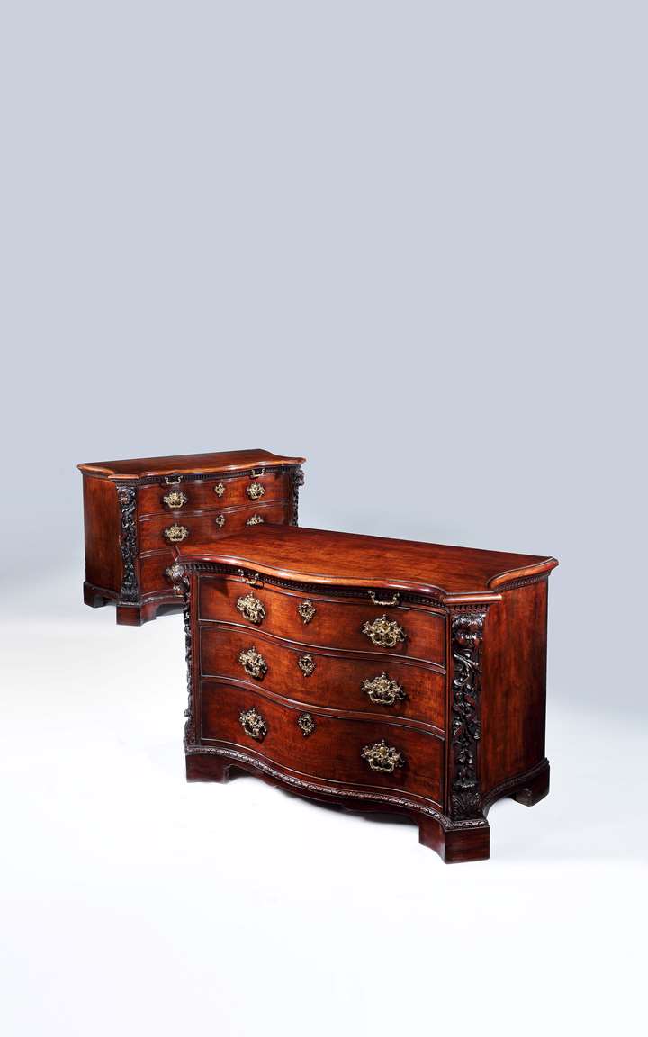 A highly important pair of serpentine fronted mahogany commodes